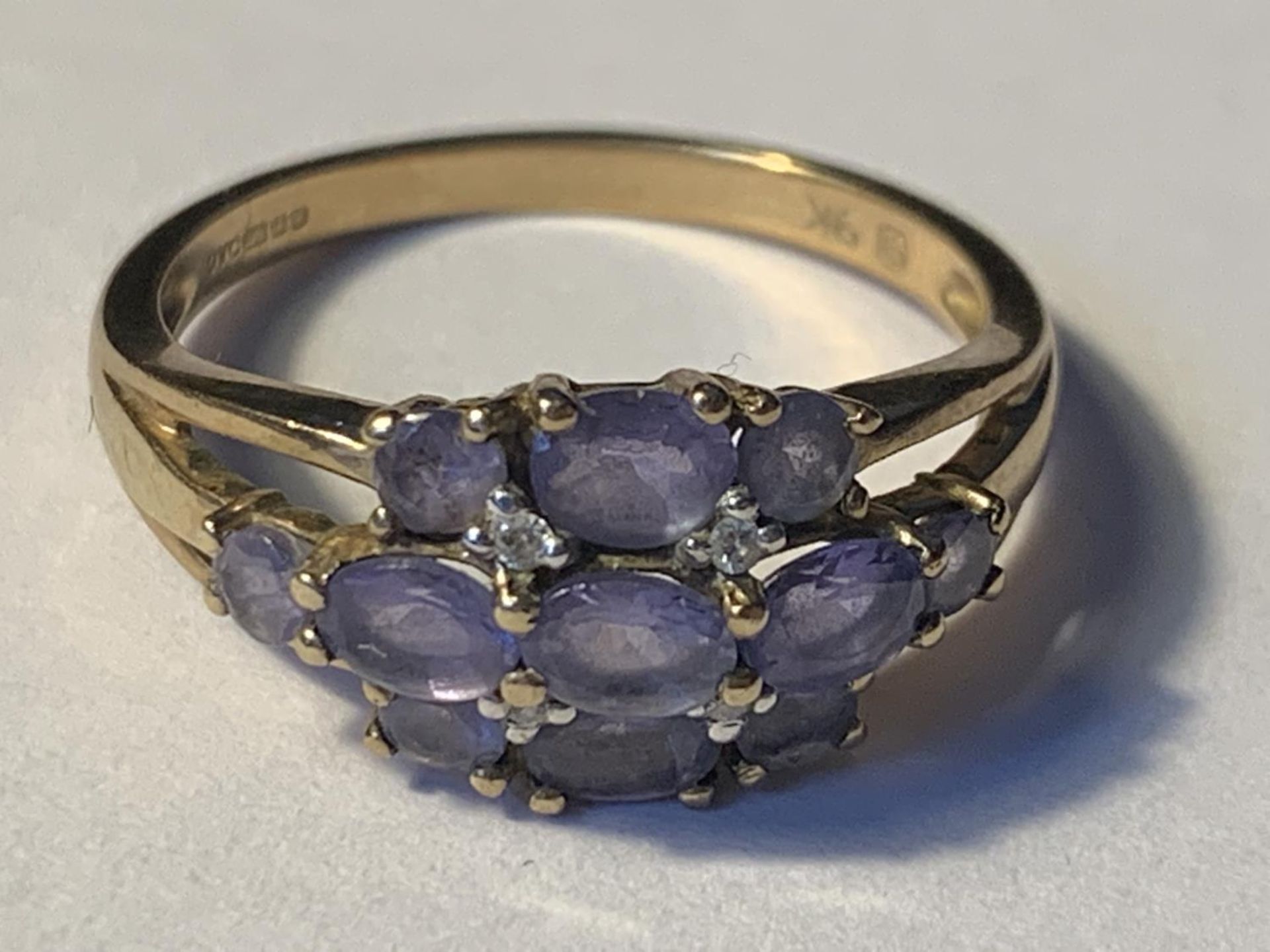 A 9 CARAT GOLD RING WITH AMETHYSTS AND DIAMONDS SIZE N/O