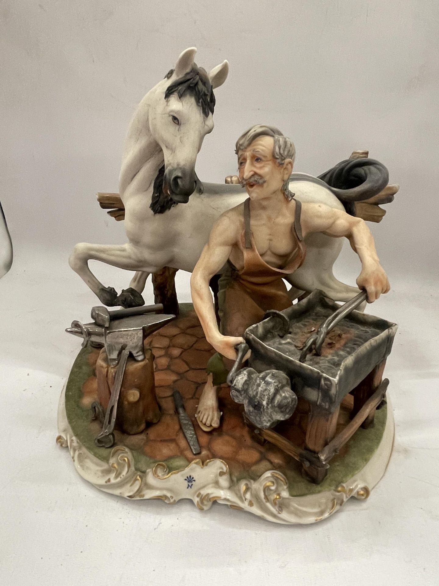 A VINTAGE CAPODIMONTE FIGURE OF A HORSE AND BLACKSMITH, SIGNED