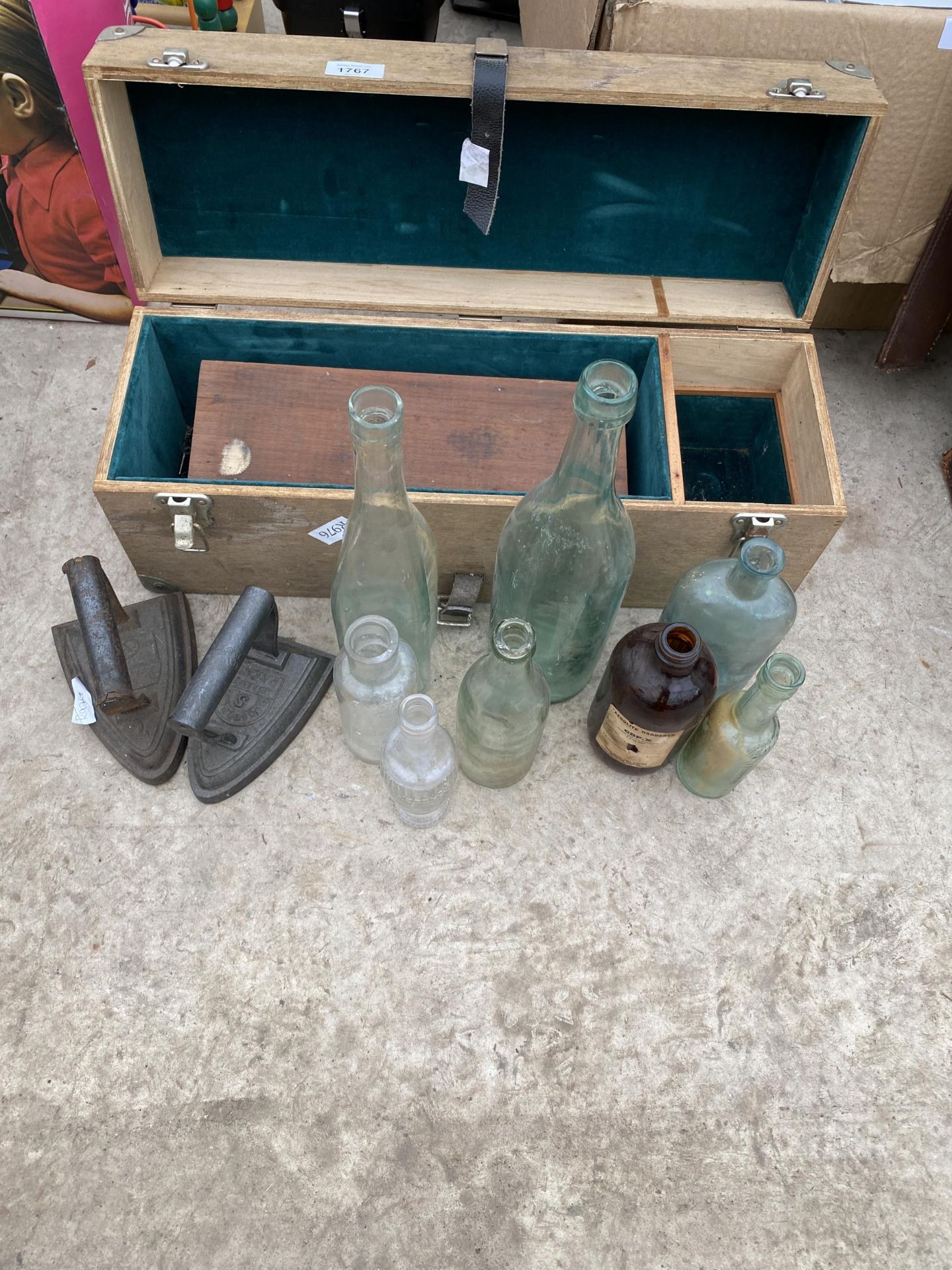 TWO WOODEN STORAGE BOXES, AN ASSORTMENT OF GLASS BOTTLES AND TWO FLAT IRONS