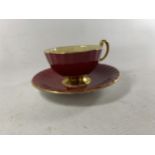 AN AYNSLEY SIGNED J.A. BAILEY OBAN SHAPED TEACUP AND SAUCER RUBY RED WITH A STUNNING FLORAL BOUQUET