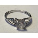 A 9 CARAT WHITE GOLD RING WITH A WITH A LARGE CENTRE CUBIC ZIRCONIA AND SMALLER TO THE SHOULDERS