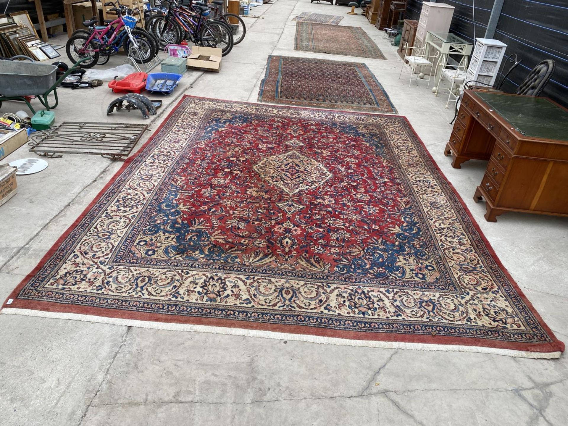 A LARGE RED PATTTERNED RUG (L:440CM)(W:320CM)