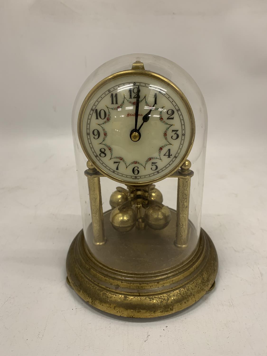 A BRASS ANNIVERSARY CLOCK WITH A DOME