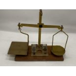 A SET OF VINTAGE WOOD AND BRASS POST OFFICE SCALES WITH SOME WEIGHTS