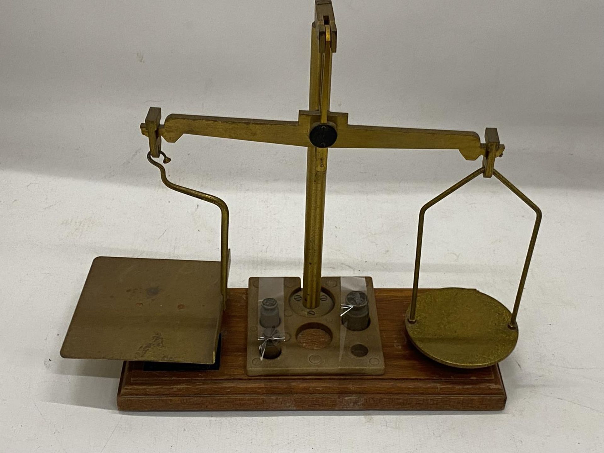 A SET OF VINTAGE WOOD AND BRASS POST OFFICE SCALES WITH SOME WEIGHTS