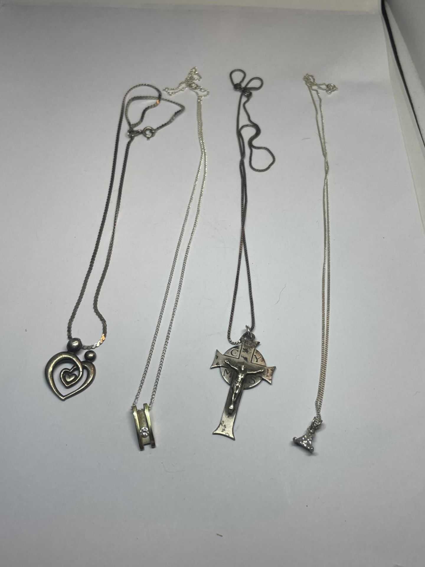 FOUR SILVER NECKLACES WITH PENDANTS