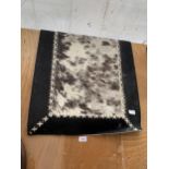 A SMALL COW HIDE STYLE RUG