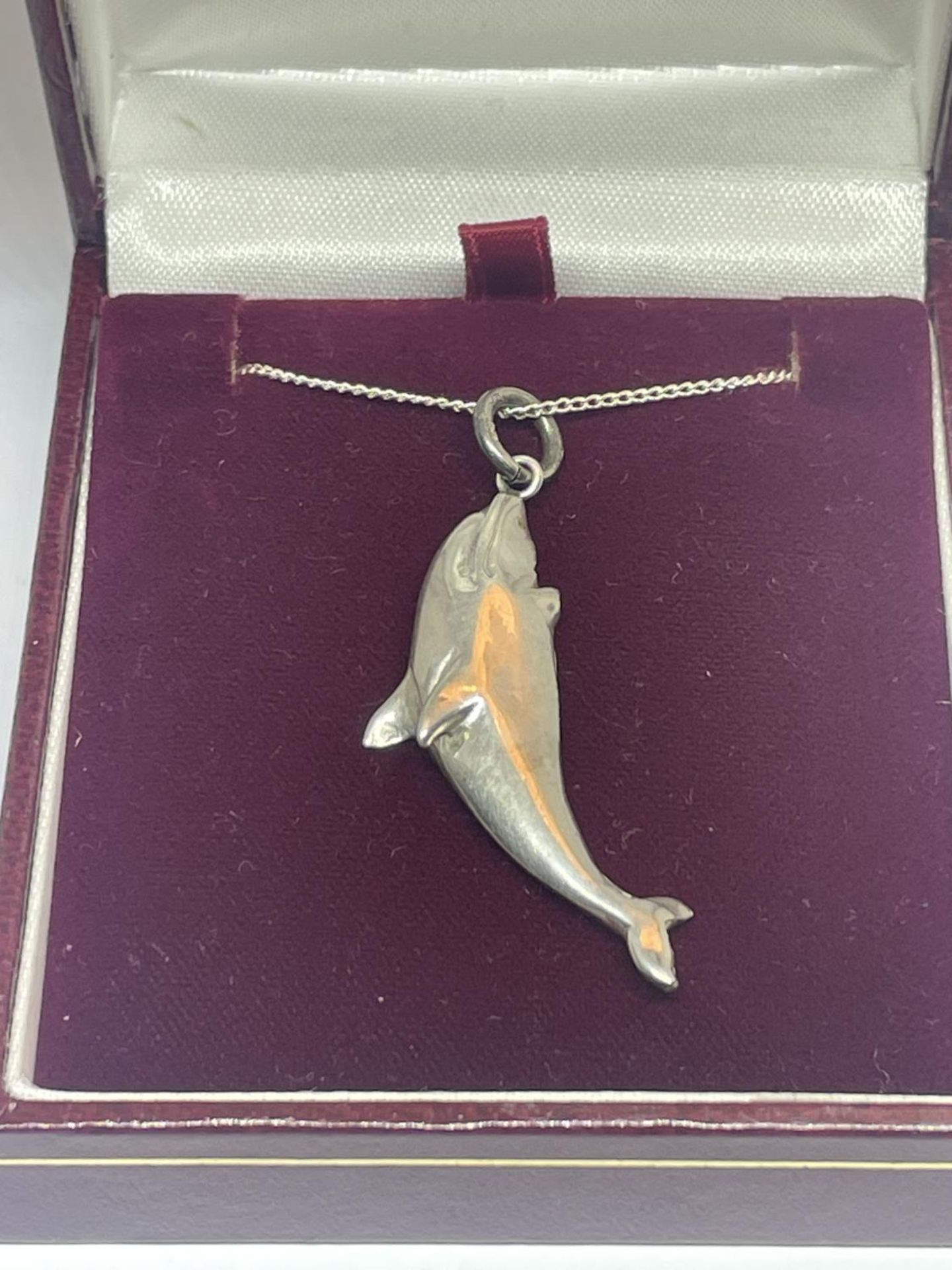 A SILVER NECKLACE WITH DOLPHIN PENDANT IN A PRESENTATION BOX