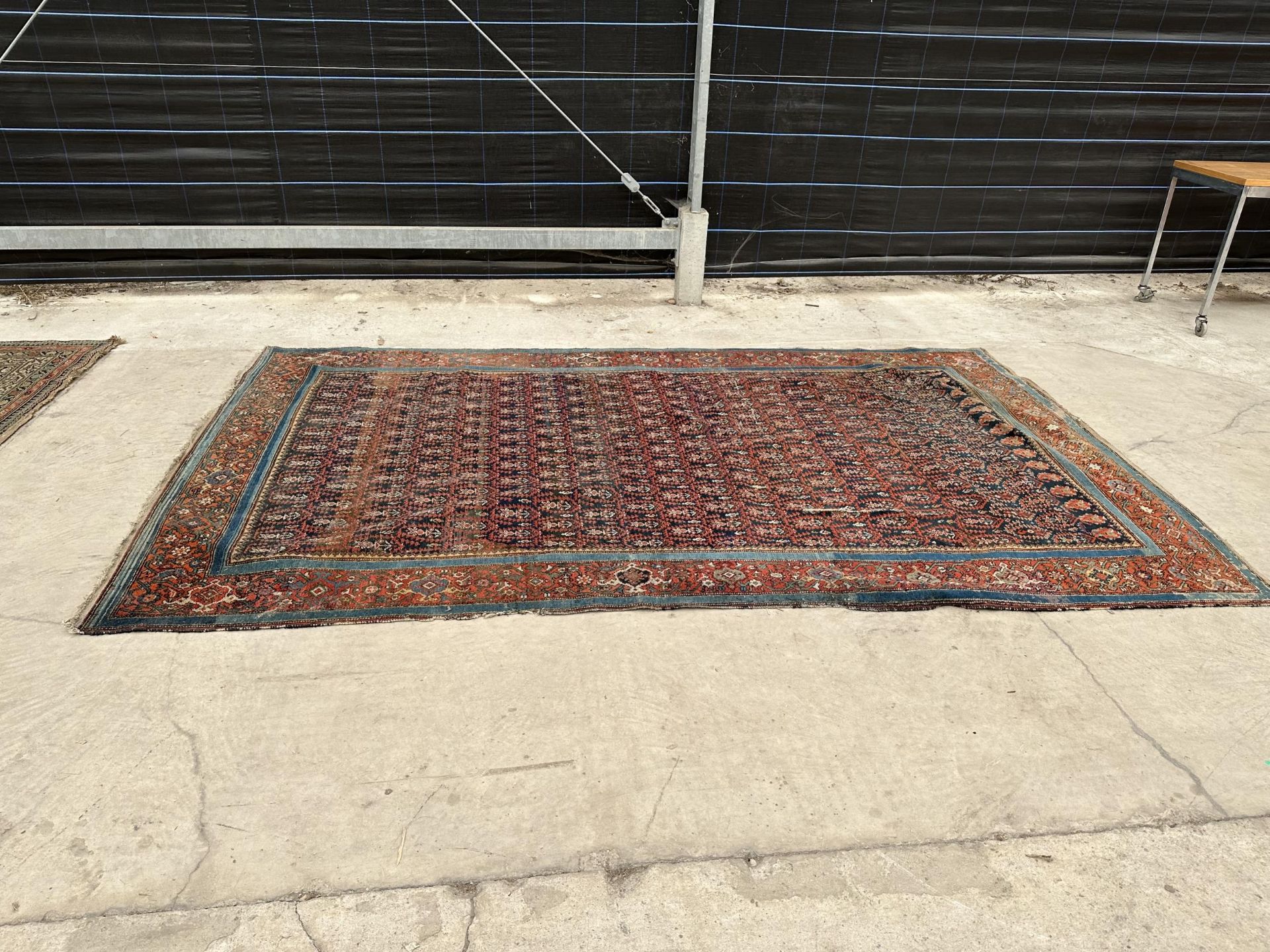 AN ANTIQUE, BELIEVED PERSIAN RUG 206 CM X 133 CM - HAS A TEAR, SEE PHOTOS 2 AND 6