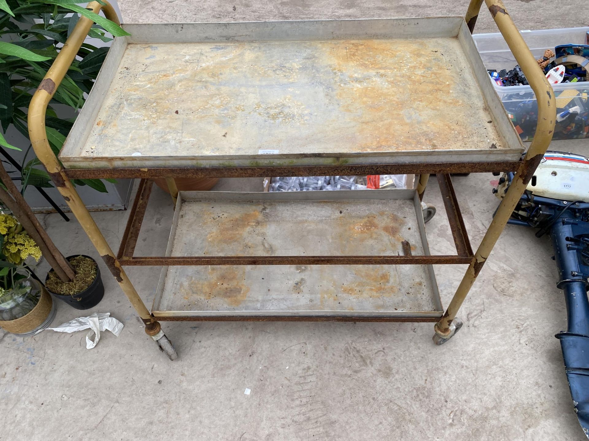 A THREE TIER METAL FOUR WHEELED TROLLEY (ONE SHELF MISSING)