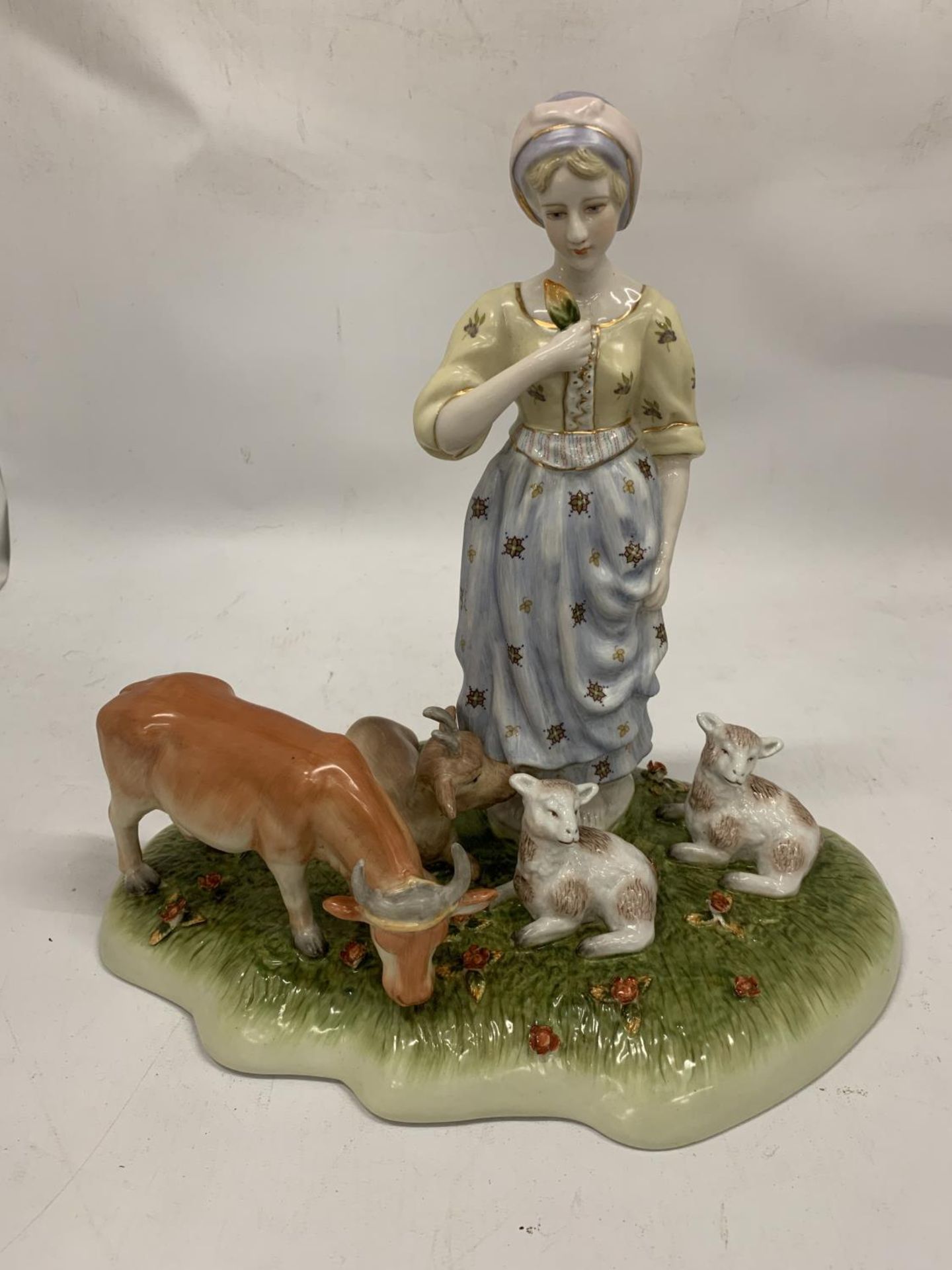 A VINTAGE CERAMIC TABLEAU OF A LADY WITH FARM ANIMALS WITH BLUE CROSSED SWORDS AND R TO BASE