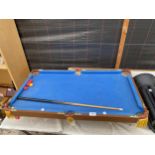 A TABLE TOP POOL TABLE WITH CUE AND BALLS