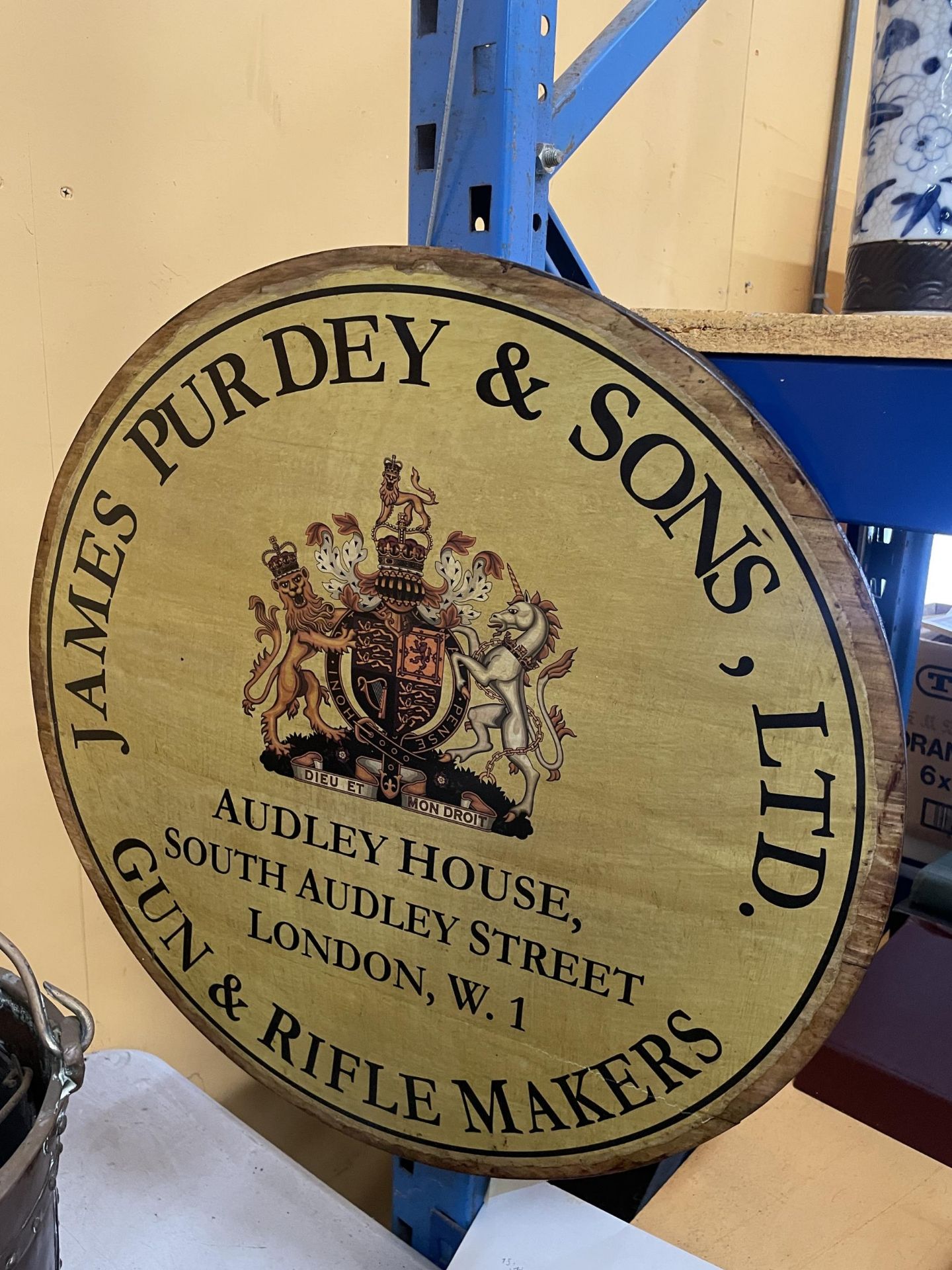 A LARGE CIRCULAR WOODEN JAMES PURDEY & SONS GUN AND RIFLE MAKERS SIGN