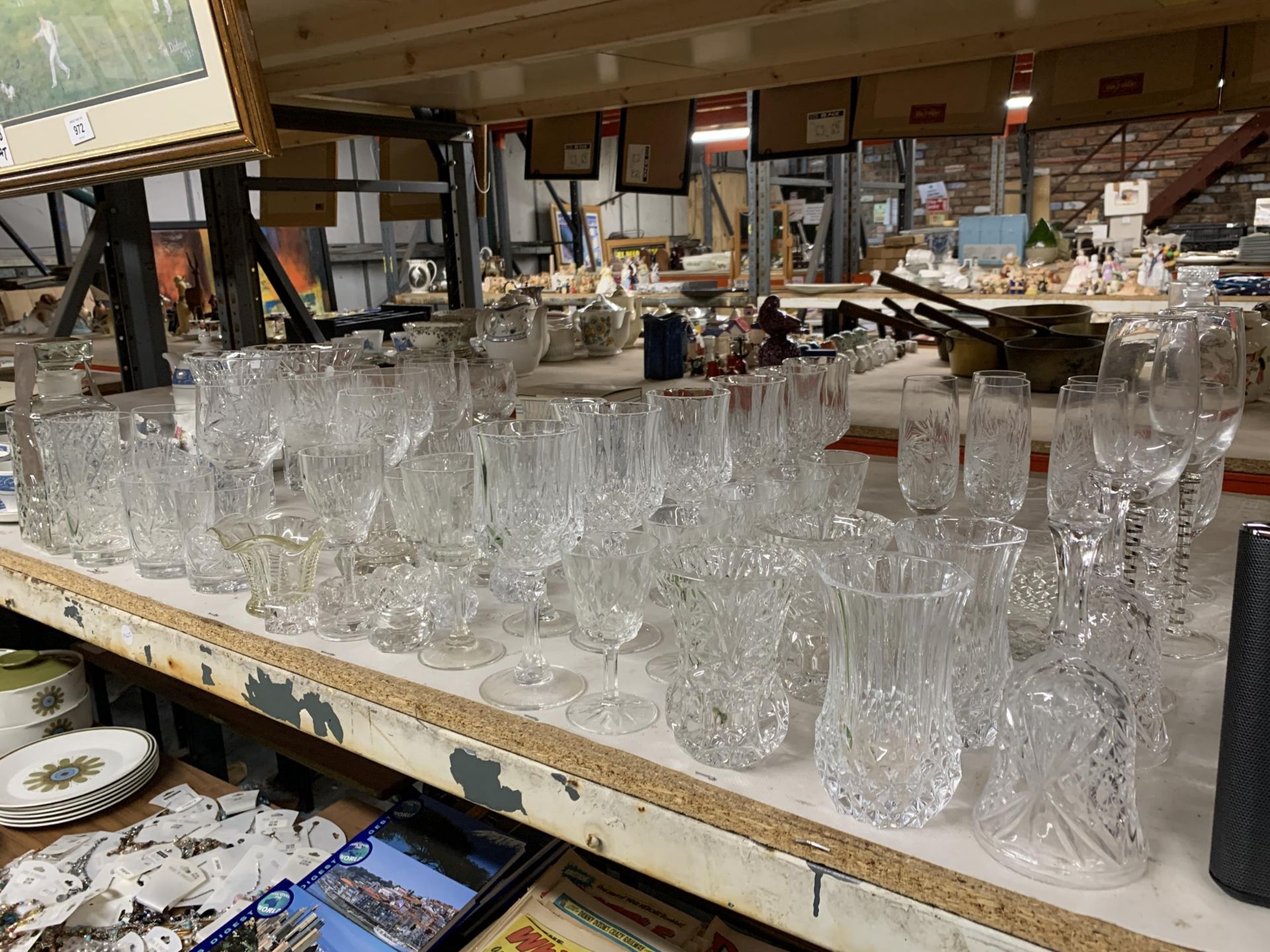 A LARGE COLLECTION OF CUT AND FURTHER GLASSWARE TO INCLUDE CHAMPAGNE FLUTES, WINE GLASSES, VASES,