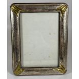 A VINTAGE HAMMERED WHITE METAL PHOTO FRAME, POSSIBLY SILVER BUT UNMARKED, 22 X 17CM