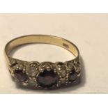 A 9 CARAT GOLD RING WITH THREE RED GARNETS AND FOUR CUBIC ZIRCONIAS SIZE U/V