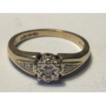 A 9 CARAT GOLD RING WITH A CENTRE DIAMOND AND DIAMONDS TO THE SHOULDERS SIZE N/O