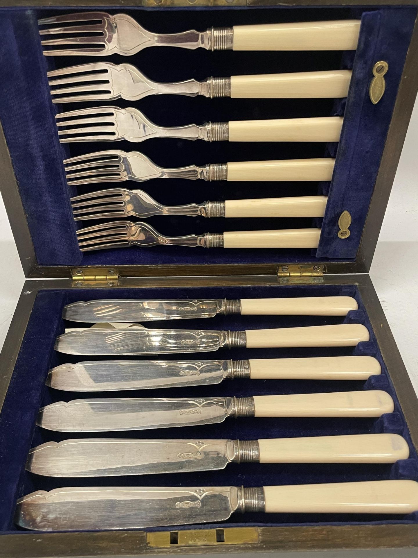 AN OAK CASED CANTEEN OF CUTLERY WITH SHEFFIELD HALLMARKED SILVER COLLARS AND BONE STYLE HANDLES - Image 2 of 4