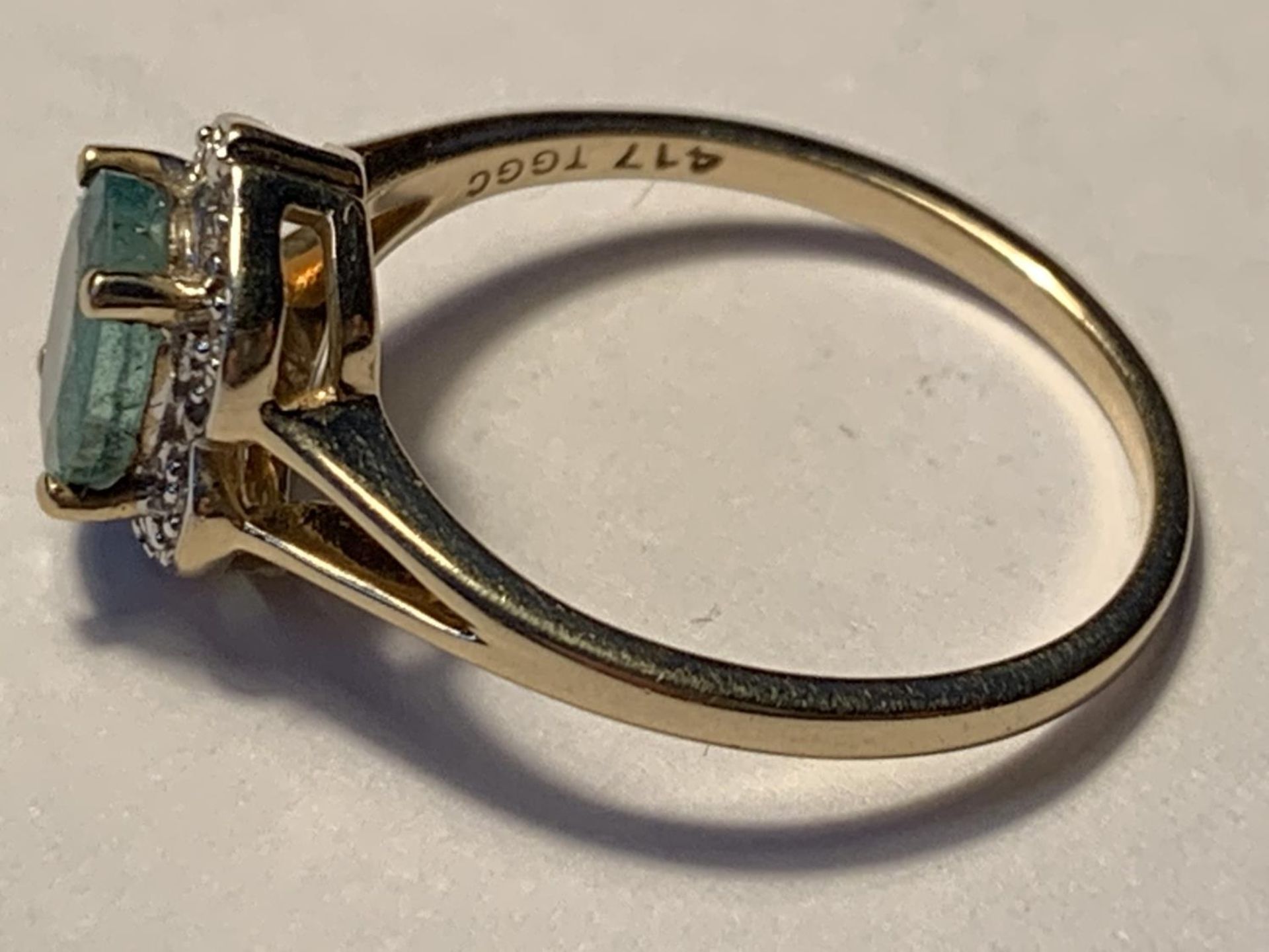 A 10 CARAT GOLD RING WITH A LARGE PERIDOT SURROUNDED BY DIAMONDS SIZE N/O - Image 2 of 3