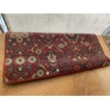 A SMALL RED PATTERNED RUG