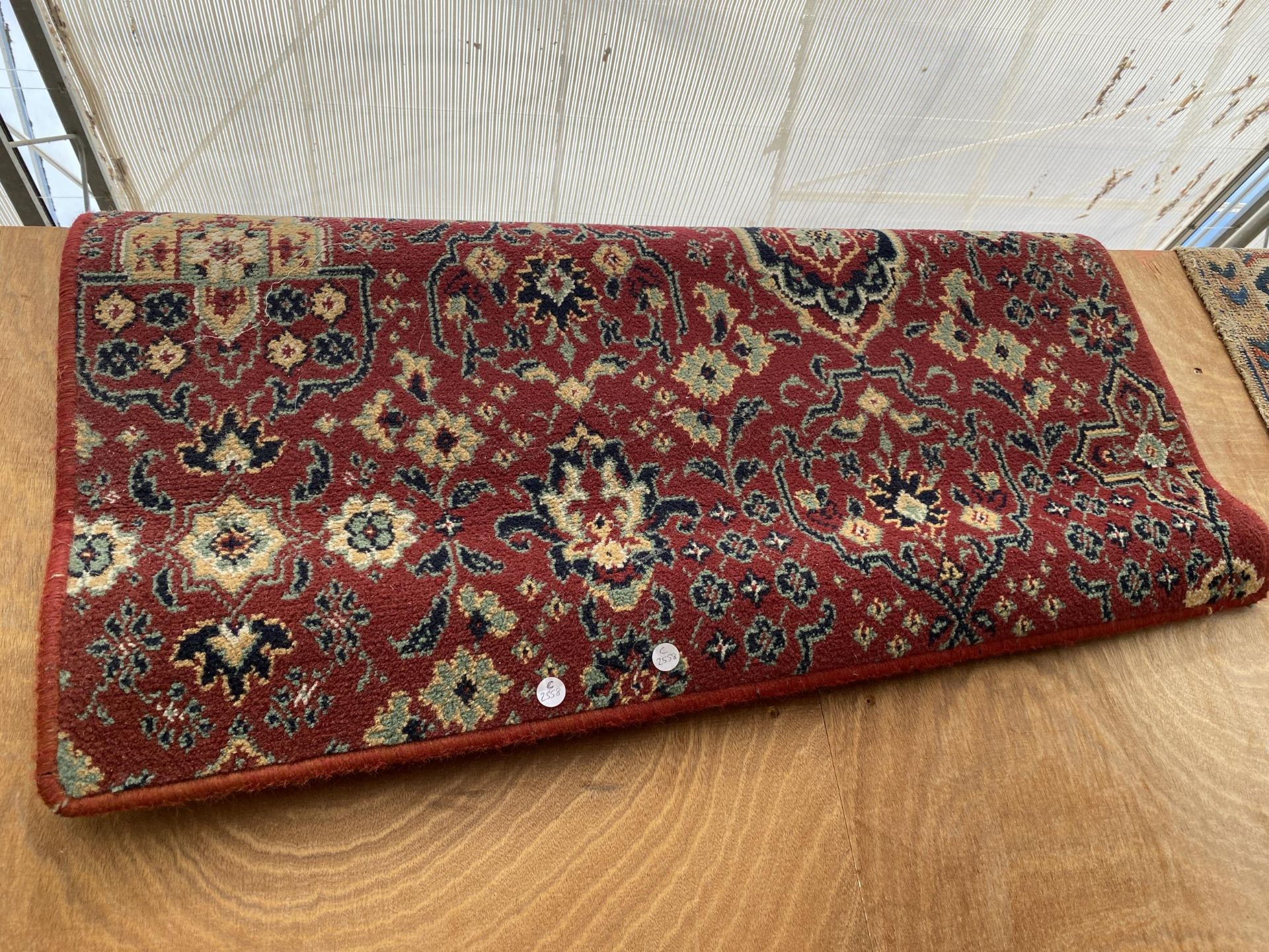 A SMALL RED PATTERNED RUG