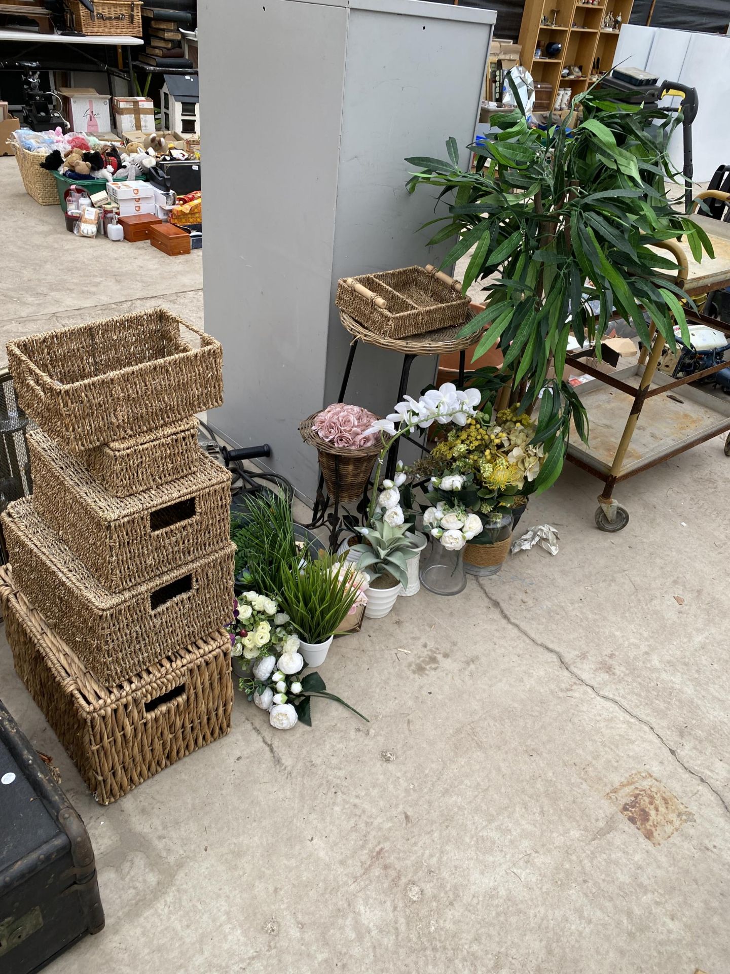 A LARGE ASSORTMENT OF FLORIST ITEMS TO INCLUDE WICKER BASKETS, PLANT STANDS AND ARTIFICIAL PLANTS