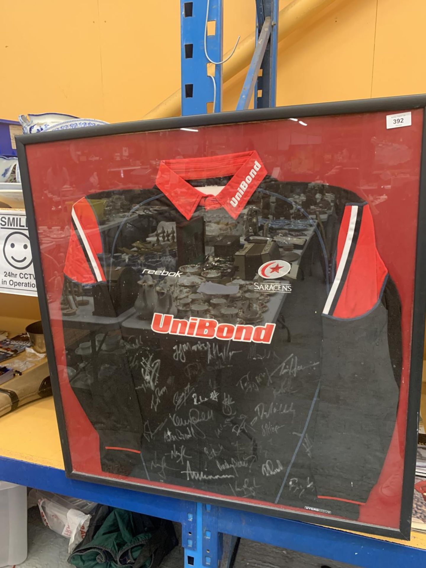 A LARGE FRAMED AND GLAZED SARACENS RUGBY UNION SHIRT, SIGNED BY THE WHOLE TEAM - NO AUTHENTITY