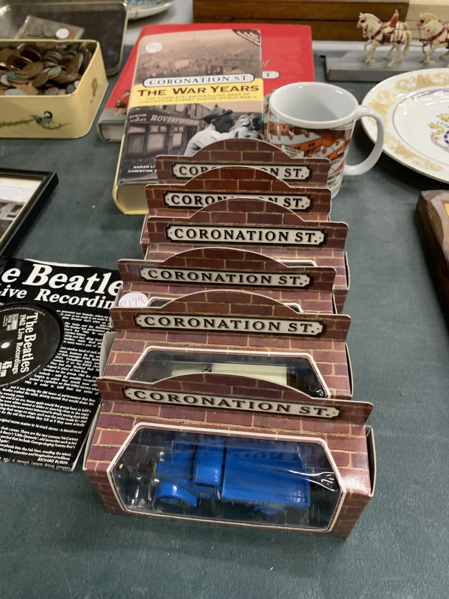 A COLLECTION OF 'CORONATION STREET' ITEMS TO INCLUDE SIX MODEL VEHICLES - BOXED, TWO BOOKS AND A MUG