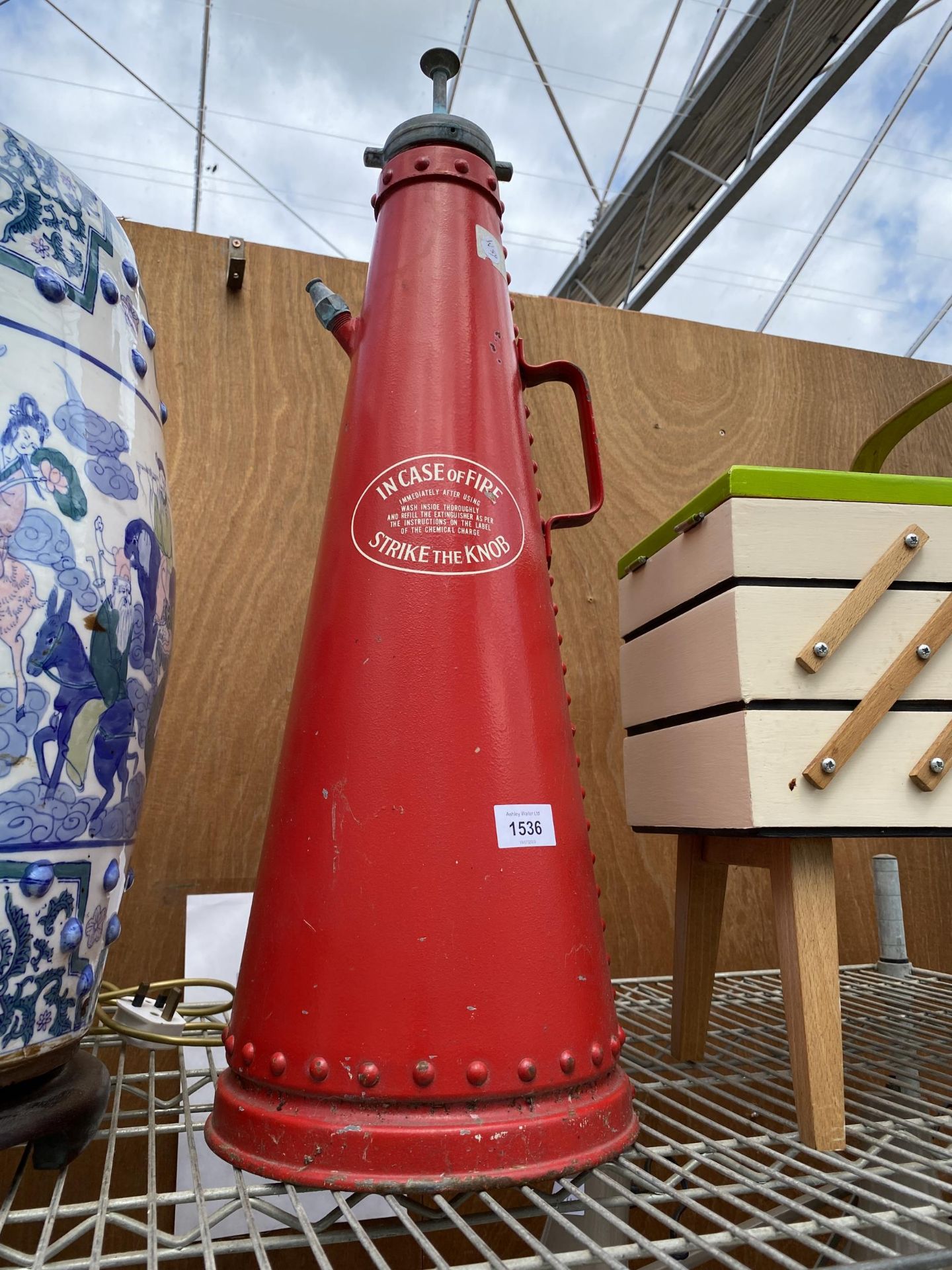 A VINTAGE RED FIRE EXTINGUISHER