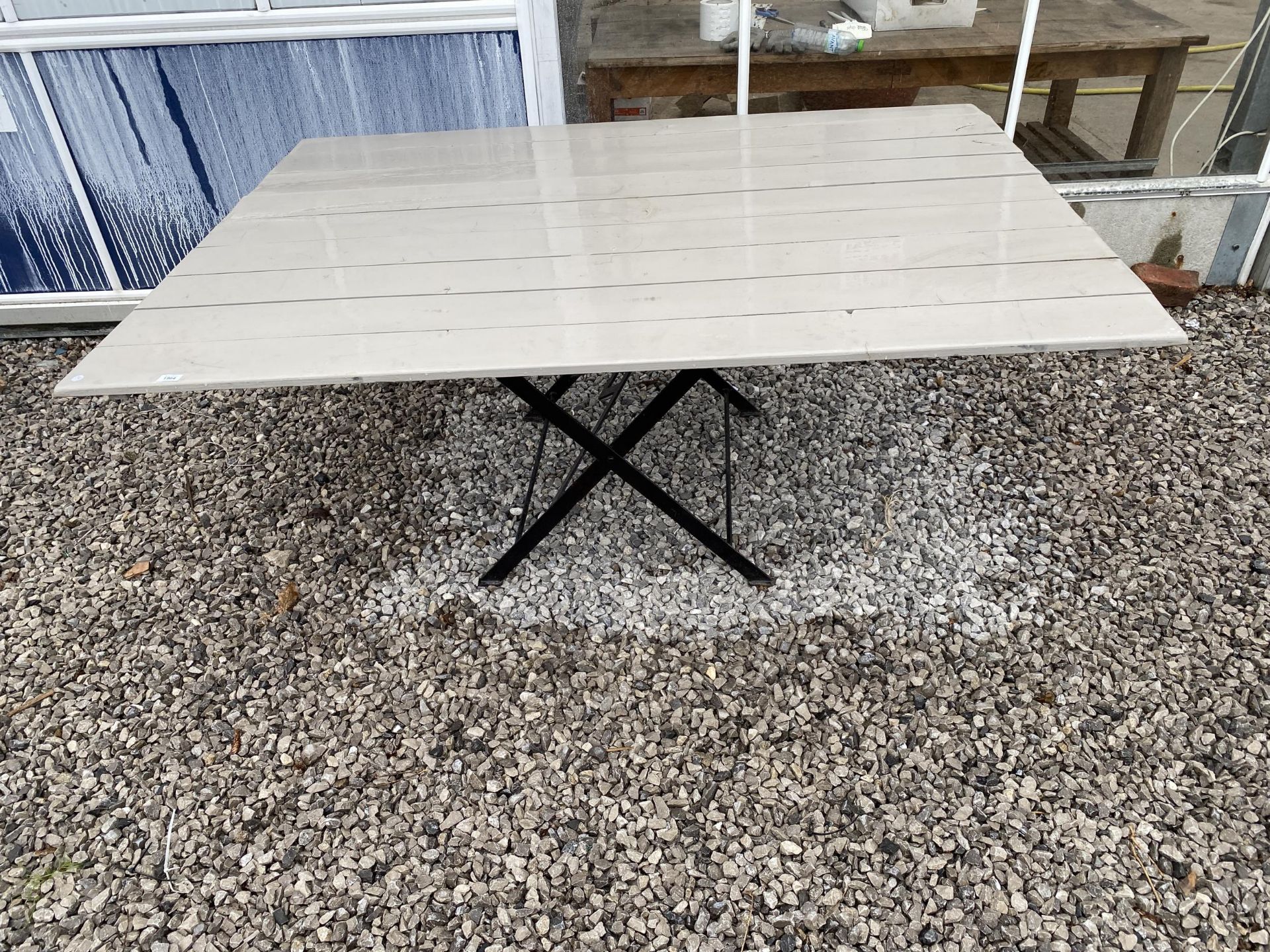 A LARGE PLANK TOP TRESTLE TABLE WITH FOLDING METAL BASE