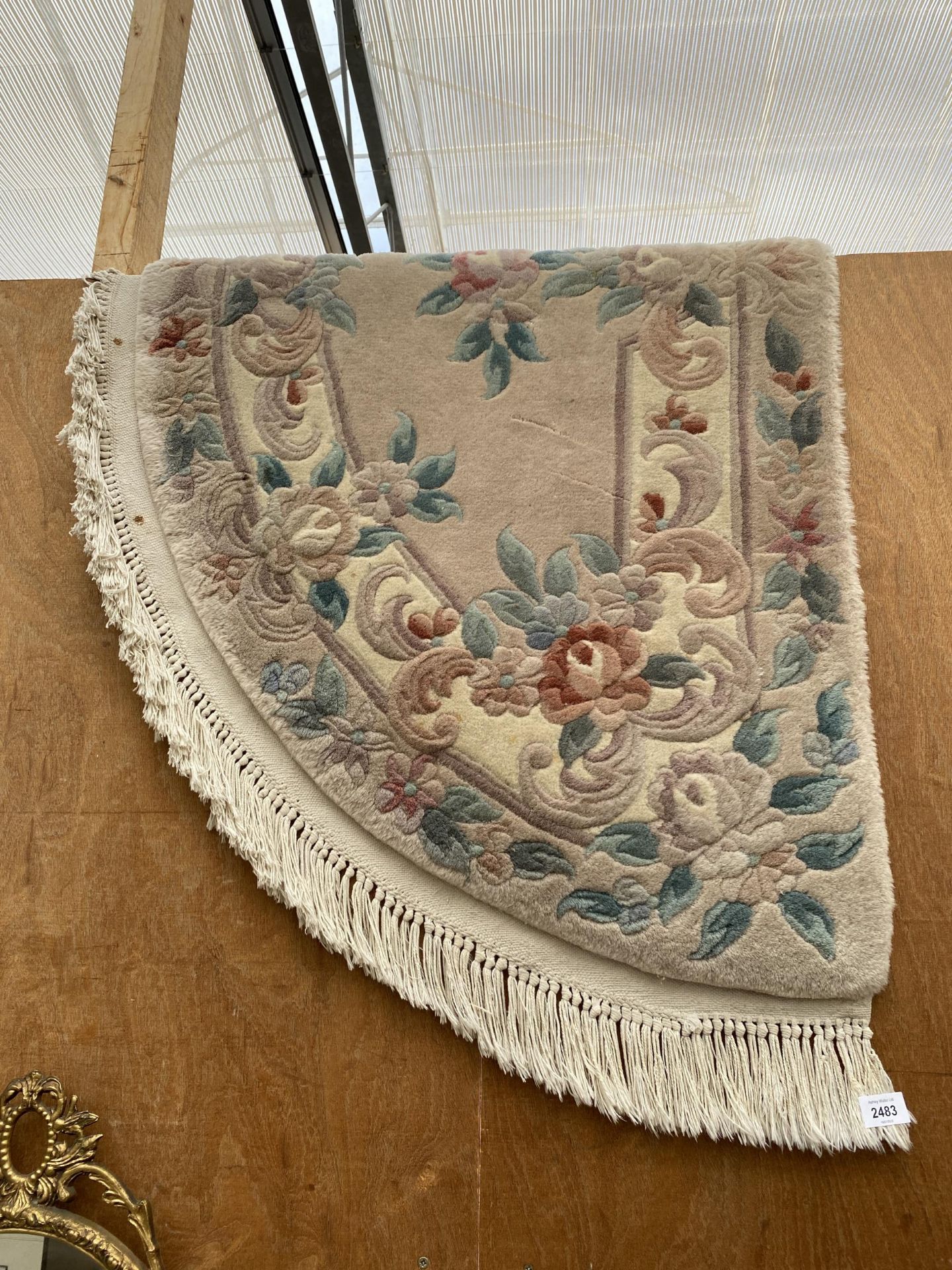 A CREAM HALF MOON FRINGED RUG