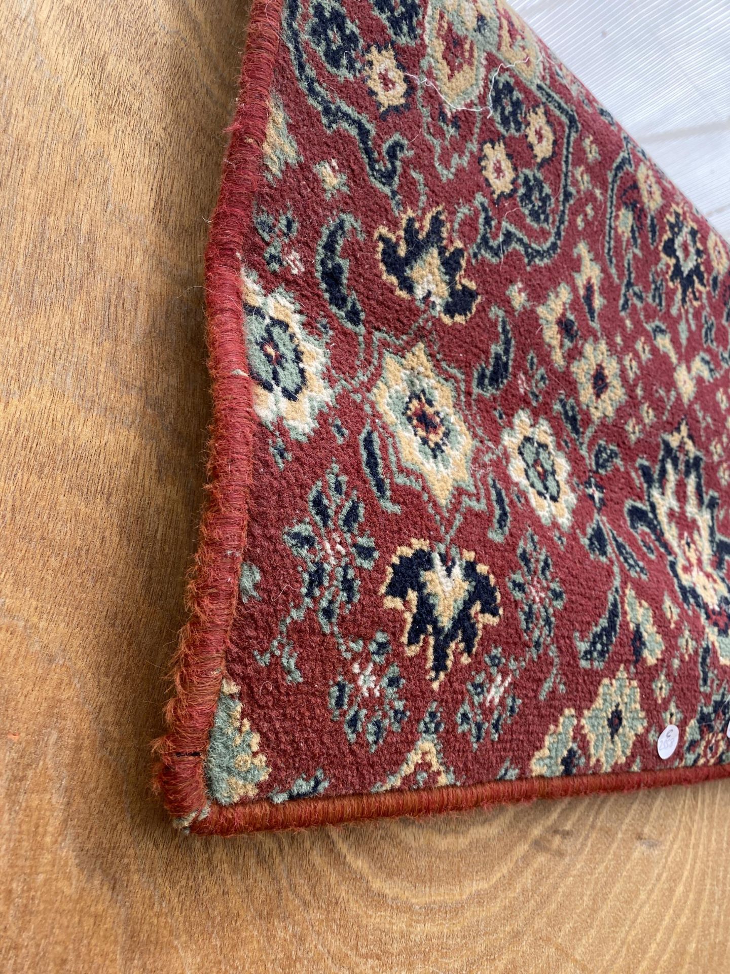 A SMALL RED PATTERNED RUG - Bild 2 aus 2
