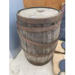 AN OAK AND METAL BANDED WHISKEY BARREL