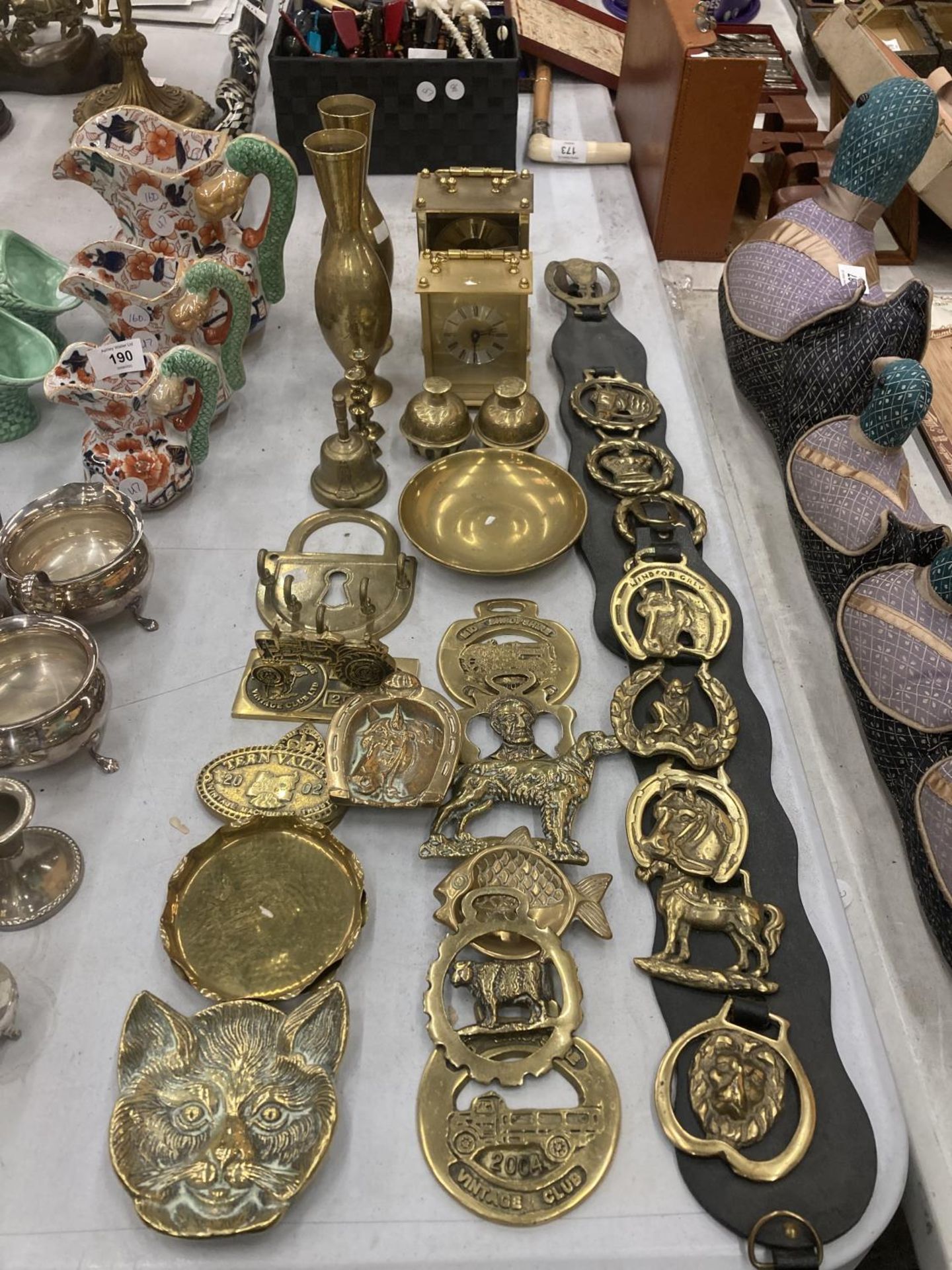 A LARGE QUANTITY OF BRASSWARE TO INCLUDE HORSE BRASSES, MARTINGALES, CARRIAGE CLOCKS, BELLS,