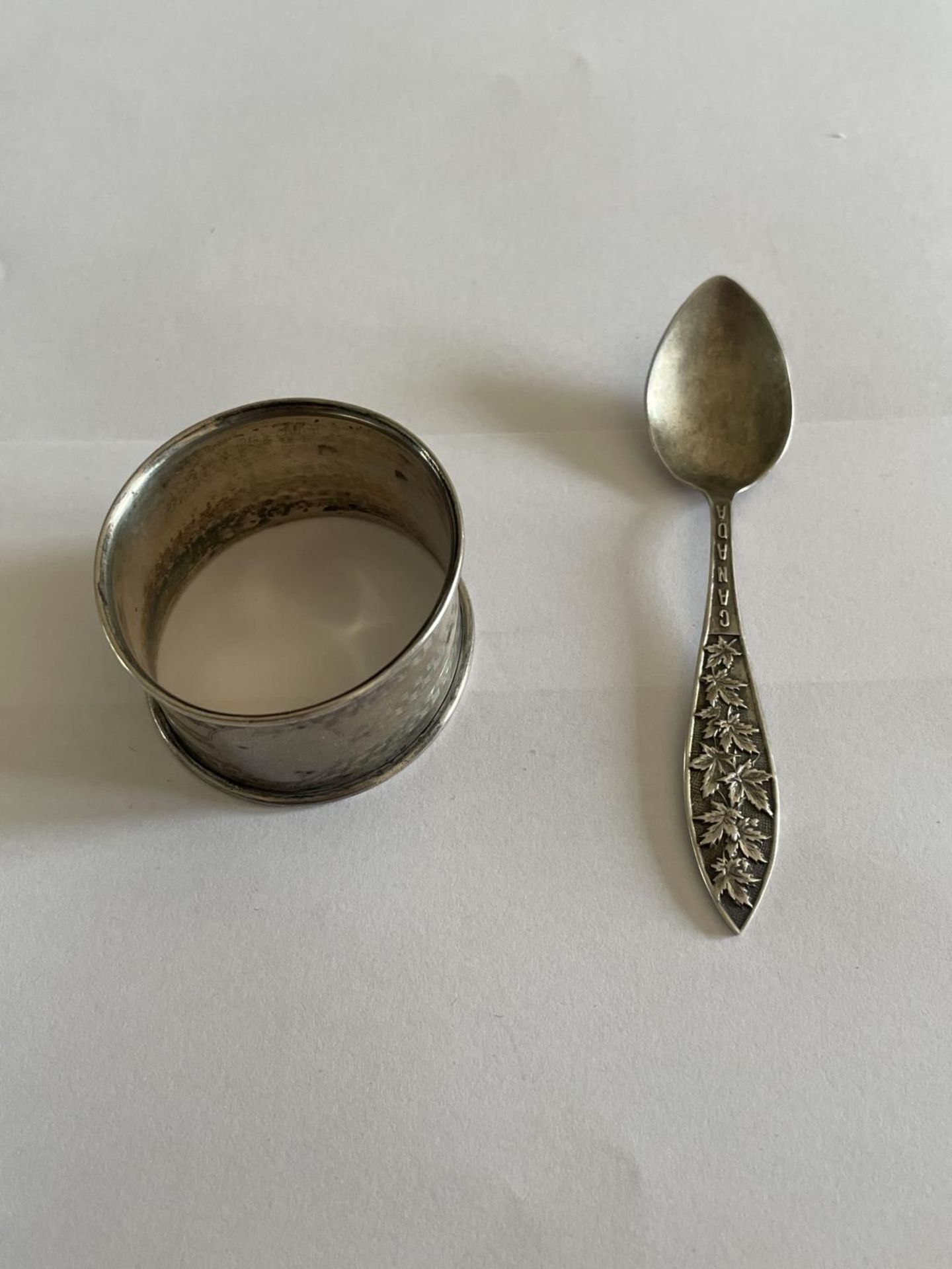 A HALLMARKED BIRMINGHAM SILVER NAPKIN RING AND A MARKED STERLING SPOON