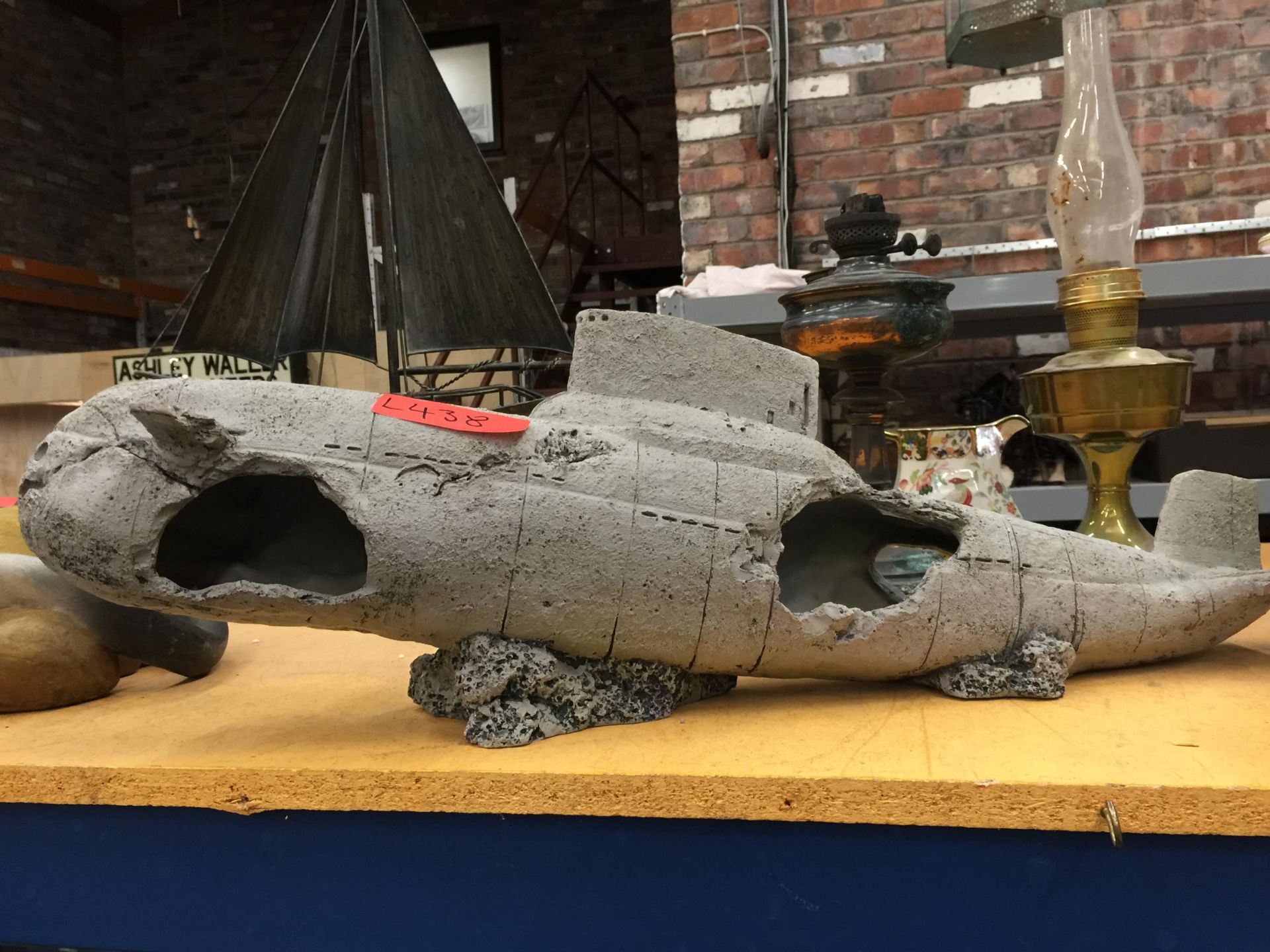 A RECONSTITUTED STONE MODEL OF A BOMBED SUBMARINE, LENGTH APPR0X 70CM