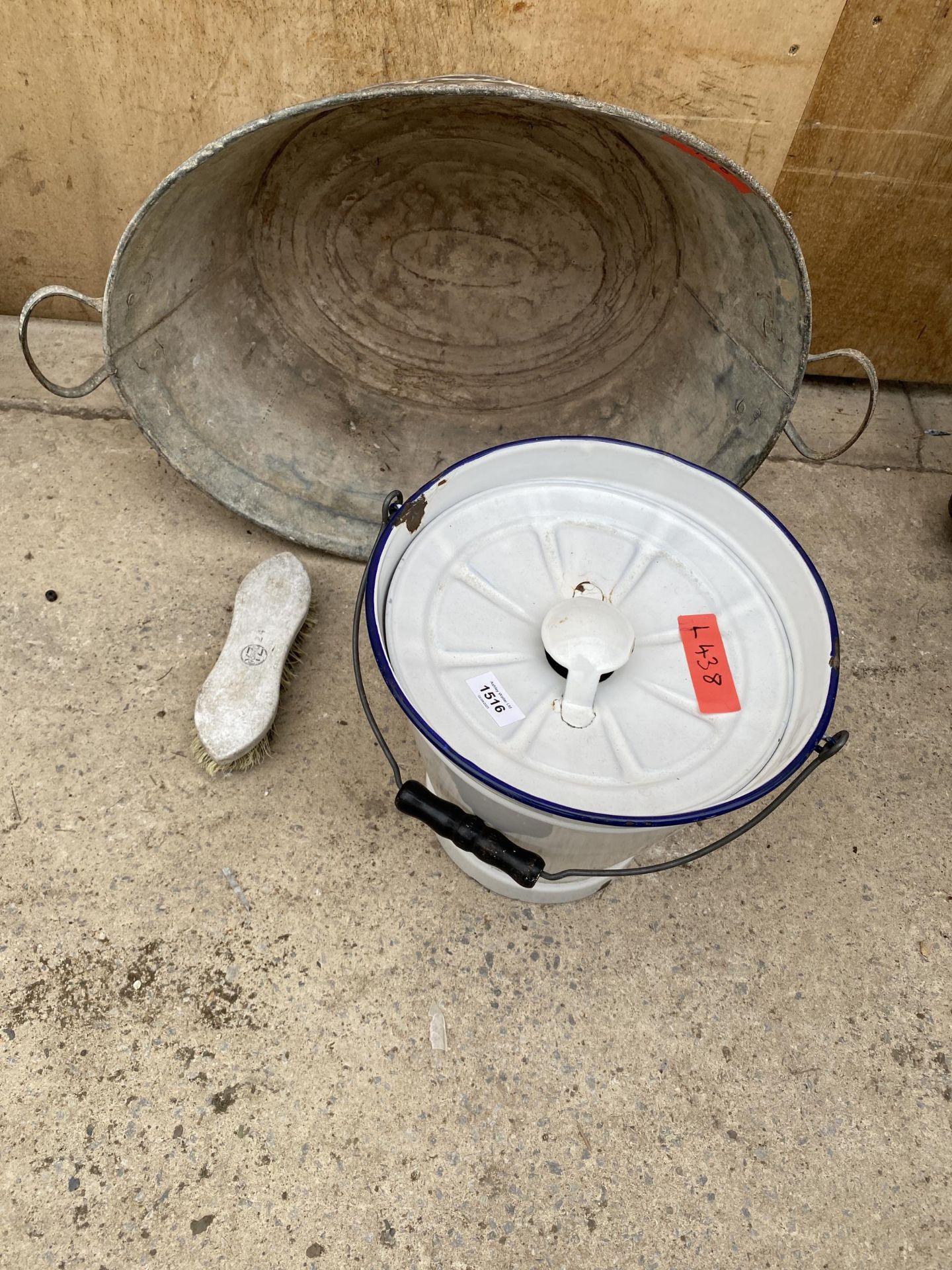 A GALVANISED TIN BATH AND AN ENAMEL SLOP BUCKET