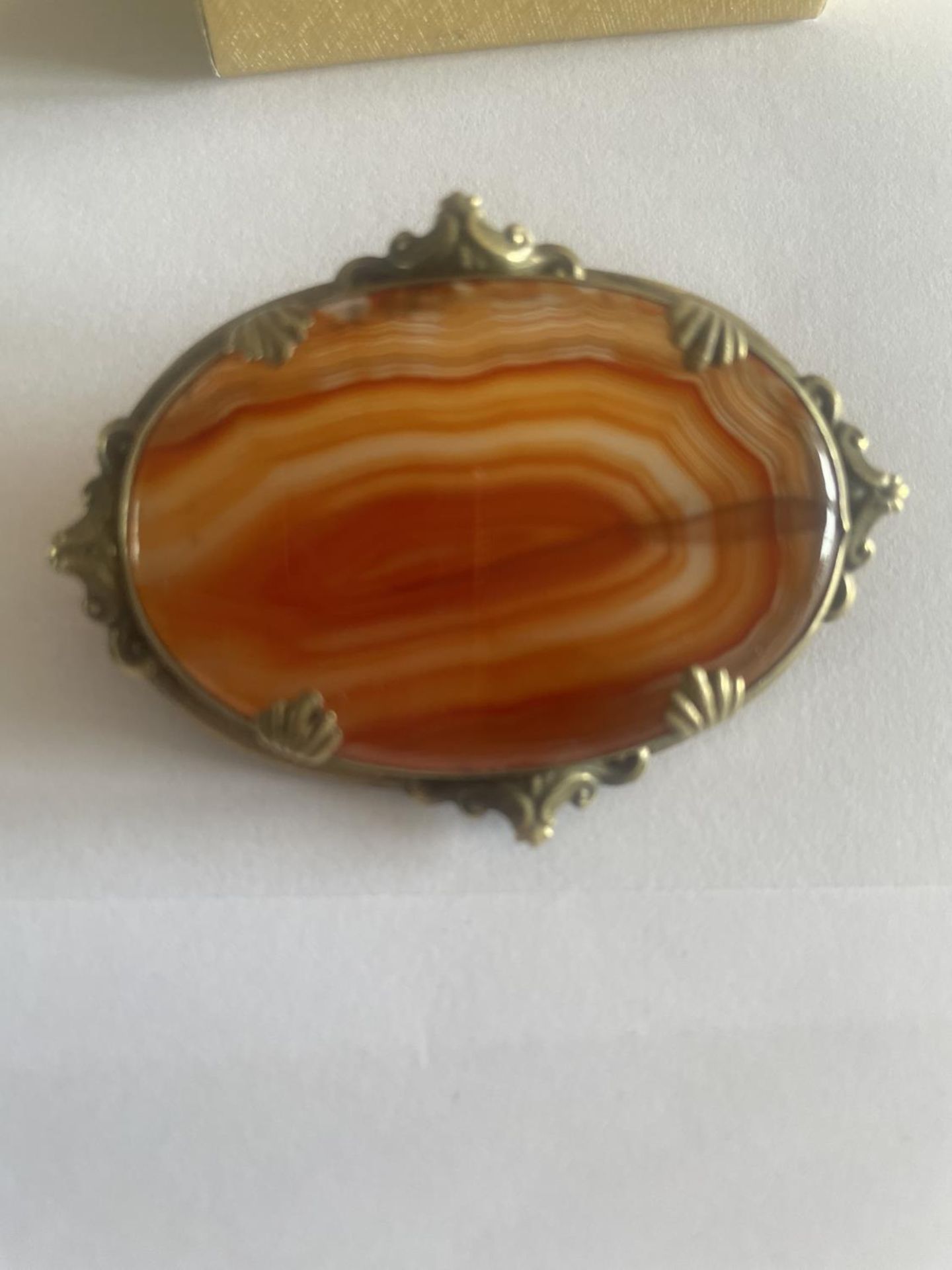 A PINCH BECK BROOCH WITH A LARGE AGATE STONE IN A PRESENTATION BOX
