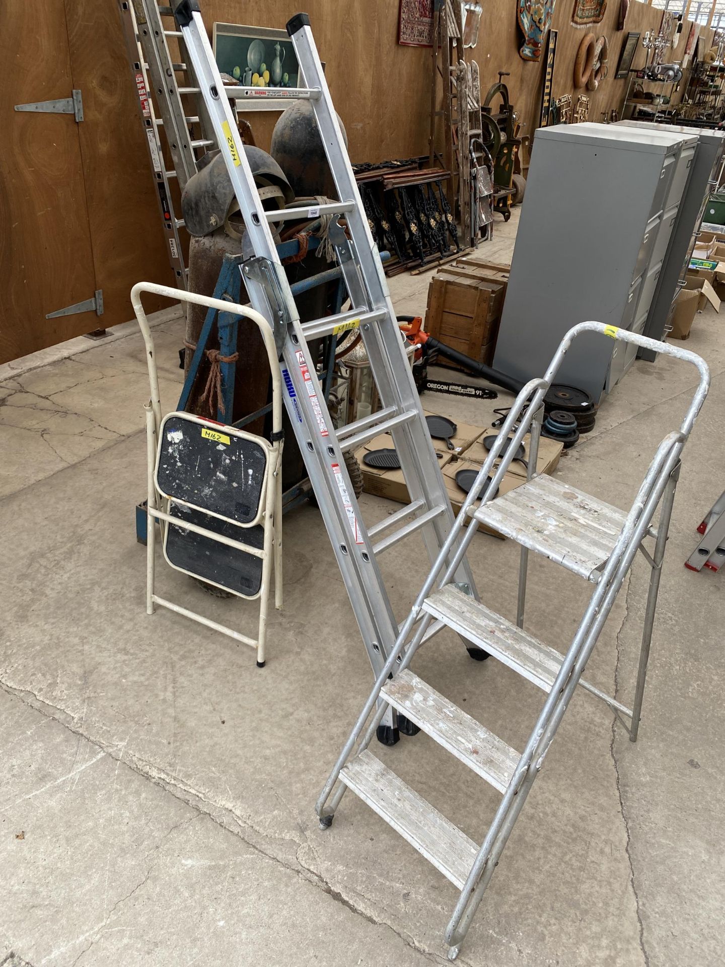 AN ASSORTMENT OF LADDERS TO INCLUDE AN ALUMINIUM ABRU THREE WAY LADDER AND TWO FURTHER STEP LADDERS