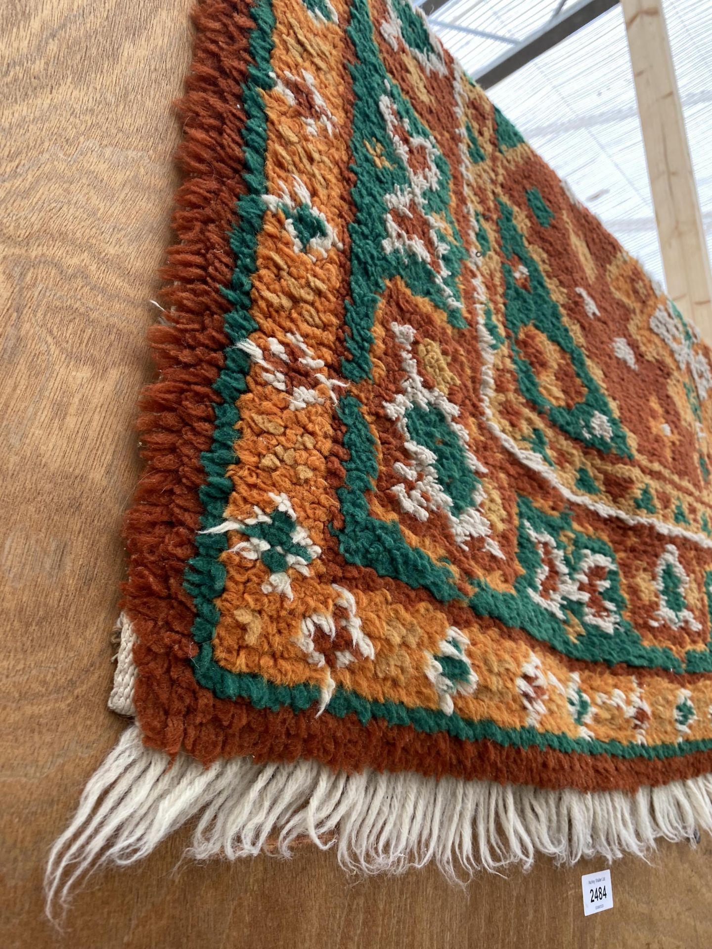 AN ORANGE AND GREEN PATTERNED FRINGED RUG - Image 2 of 2