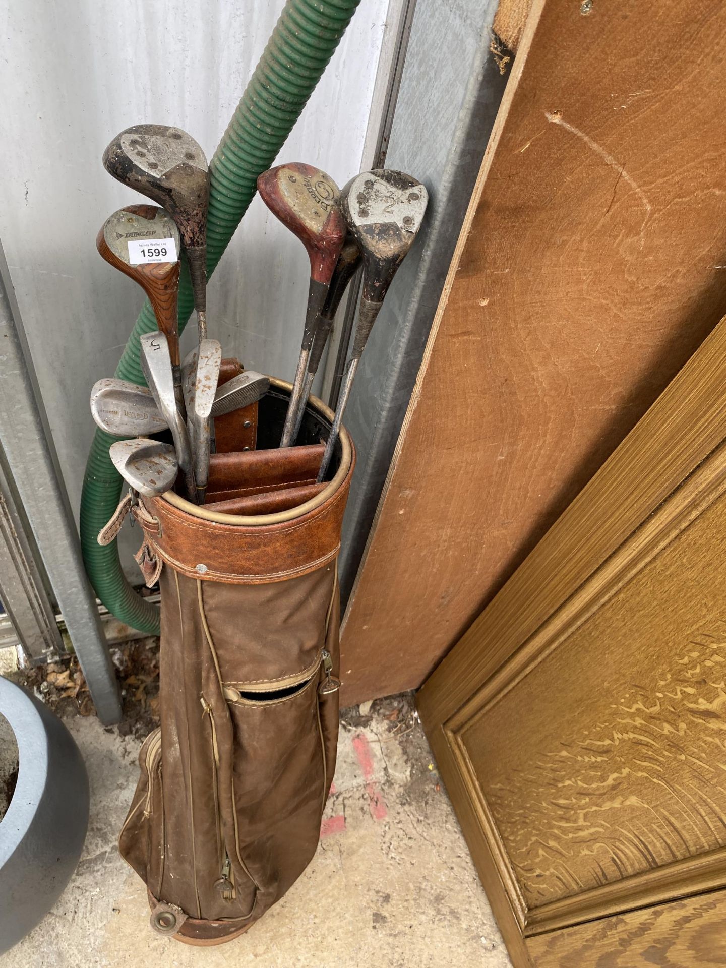 A VINTAGE GOLF BAG AND AN ASSORTMENT OF VINTAGE GOLF CLUBS