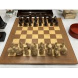A CHESS SET WITH A WOODEN BOARD AND ALICE IN WONDERLAND THEMED PLAYING PIECES