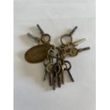 ELEVEN POCKET WATCH KEYS ON A KEYRING