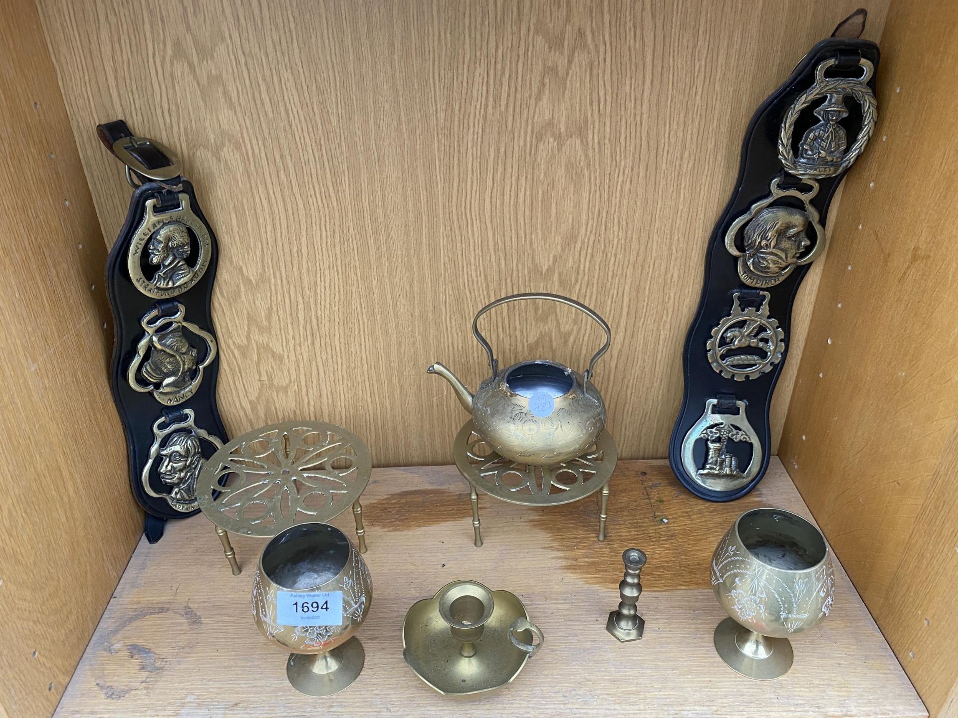 AN ASSORTMENT OF BRASS ITEMS TO INCLUDE HORSE BRASSES, GOBLETS AND TRIVET STANDS ETC