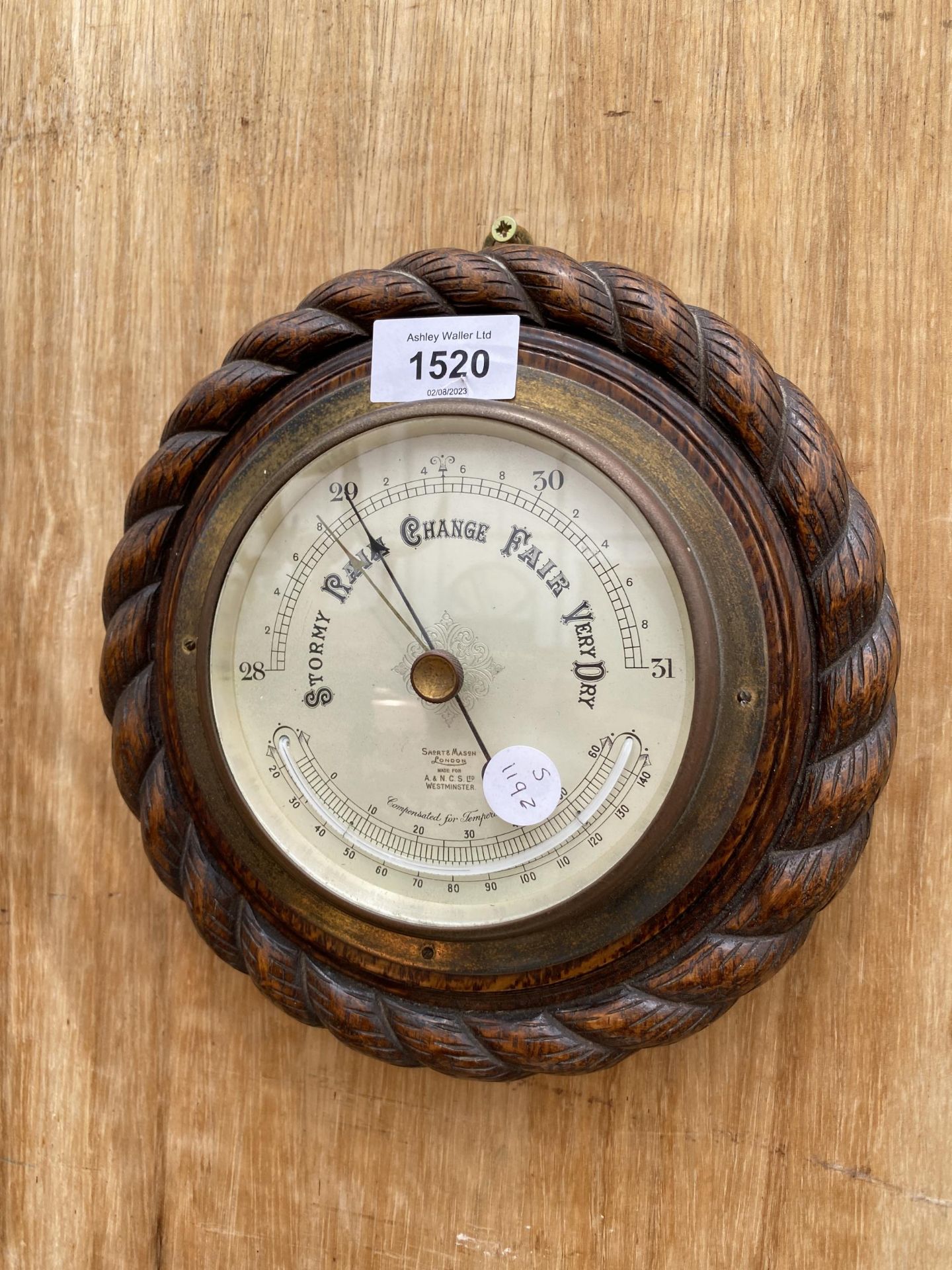 A SMALL CIRCULAR OAK CASED BAROMETER