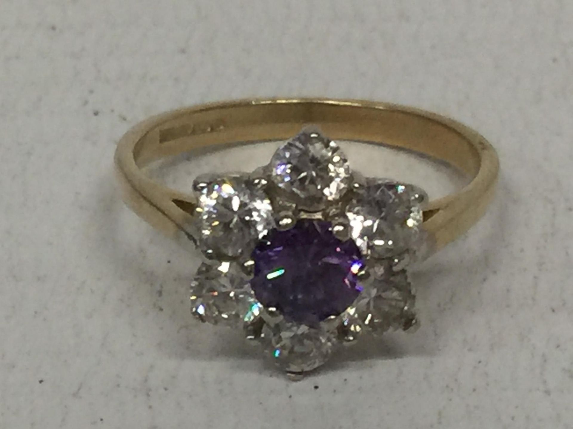 A 9 CARAT GOLD RING WITH PURPLE STONES AND CUBIC ZIRCONIAS