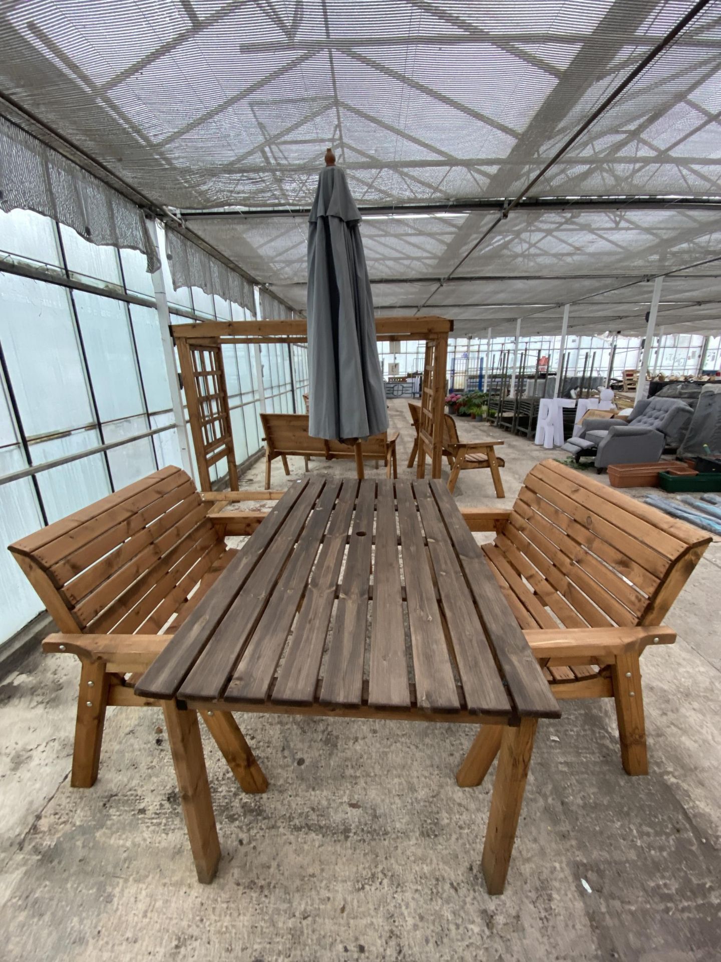 AN AS NEW EX DISPLAY CHARLES TAYLOR GARDEN TABLE, A PAIR OF TWO SEATER BENCHES AND A PARASOL *PLEASE