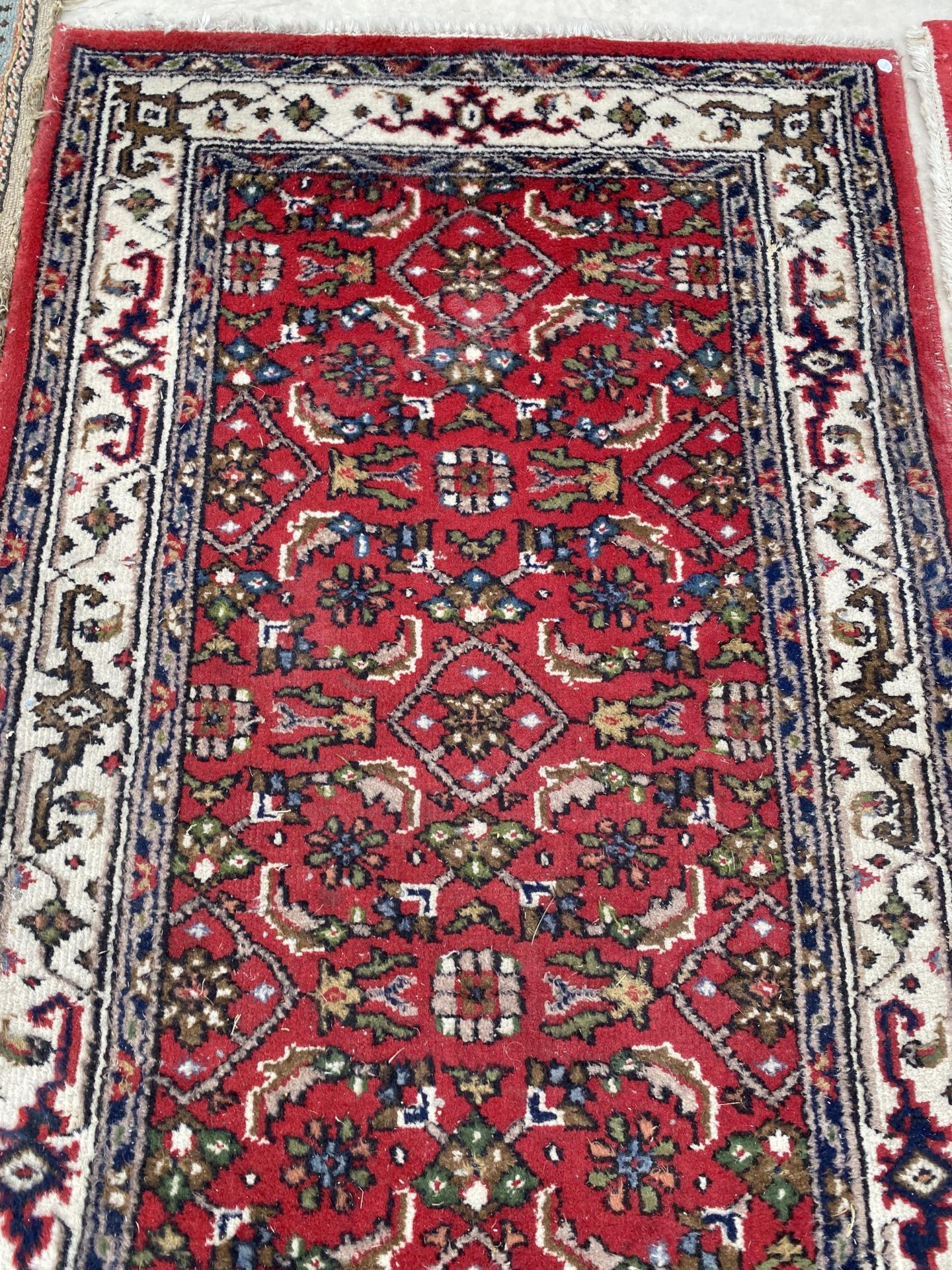 A SMALL RED PATTERNED FRINGED RUG - Image 2 of 3