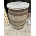A METAL BANDED OAK WHISKEY BARREL WITH ROUND TIMBER TOP