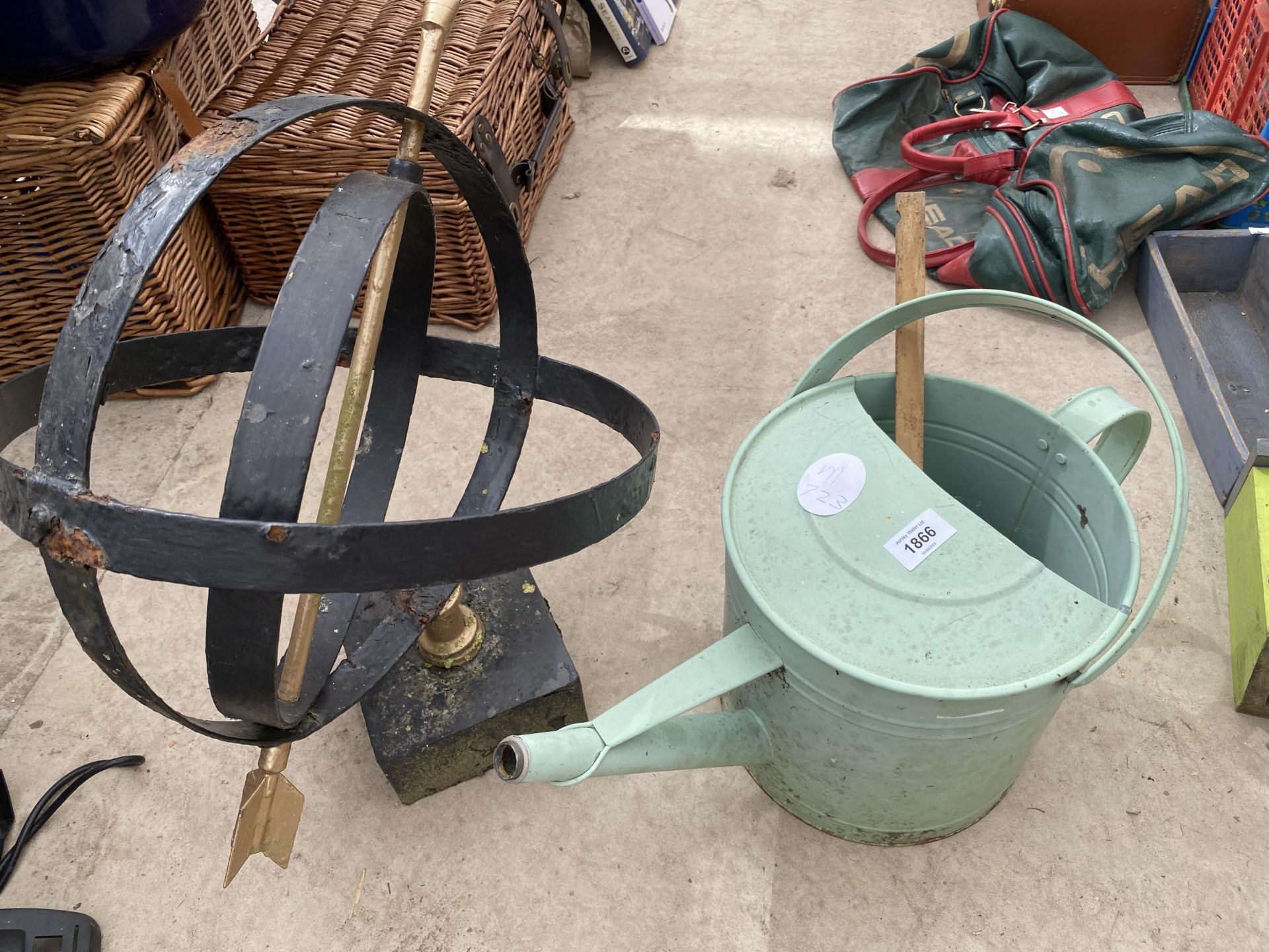 A PAINTED METAL WATERING CAN AND AN ARMILARY SPHERE